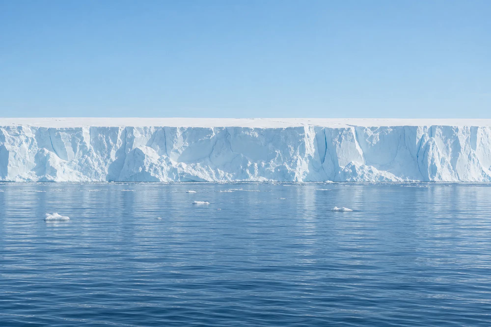 An ice shelf under a pale blue sky